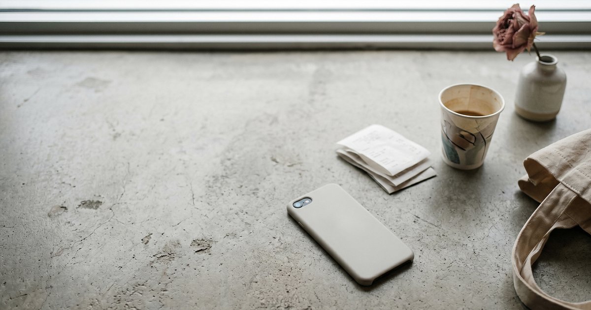Smartphone sobre mesa com aplicativo de marketplace mostrando aviso de bloqueio