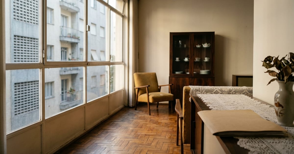 Sala de casa antiga com móveis de família e luz entrando pela janela